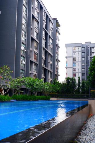 a swimming pool in front of two tall buildings at BOHO Geniehome 3BR free W-ifi @ Utropolis ShahAlam in Shah Alam