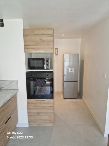 une cuisine avec un réfrigérateur en acier inoxydable et un micro-ondes dans l'établissement CHEZ LALLA, à Marseille