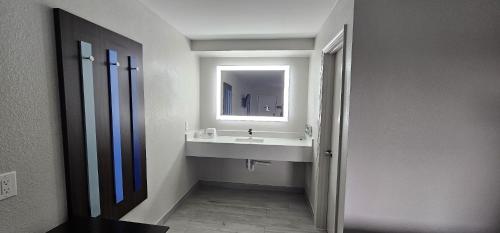 a bathroom with a sink and a mirror at Days Inn by Wyndham Indianapolis East Post Road in Indianapolis