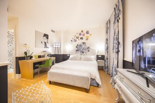 a living room with a large bed and a television at Cinque Rooms in Verona