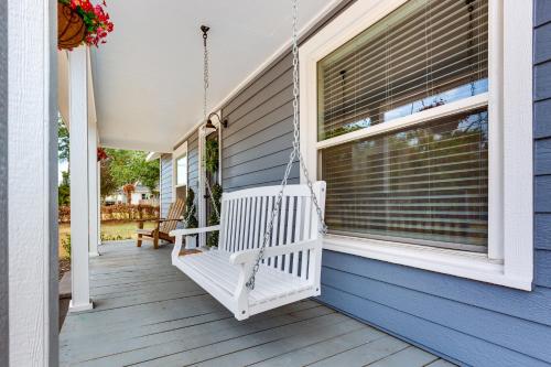 a porch swing hanging off the side of a blue house at Lindale Vacation Rental with Deck and Grill! in Lindale
