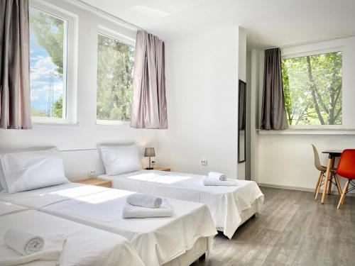 two beds in a room with two windows at Hello Studios Budget Stays Free Parking & Wifi in Stara Zagora