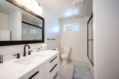 a bathroom with a sink and a toilet and a mirror at Morro Bay Vacation Rentals in Morro Bay