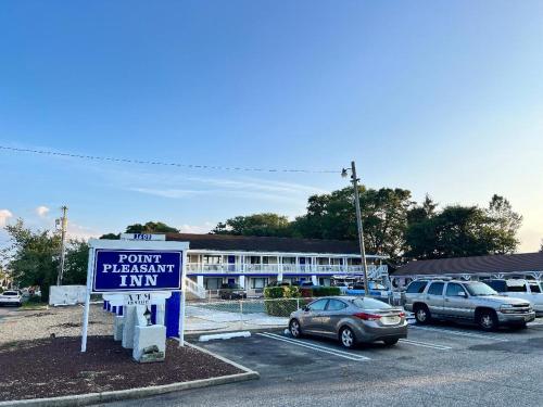a sign in a parking lot in front of a hotel at Point Pleasant Inn in Point Pleasant Beach
