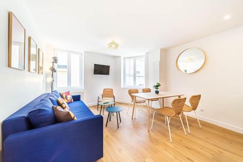 uma sala de estar com um sofá azul e uma mesa em Le Marcellin charmant 6 pers Sainte-Foy-lès-Lyon em Sainte-Foy-lès-Lyon
