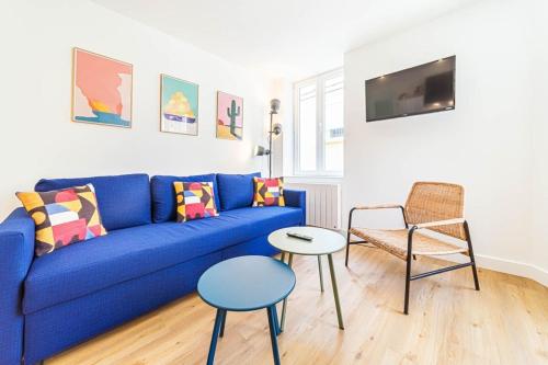 ein Wohnzimmer mit einem blauen Sofa und einem Stuhl in der Unterkunft Le Marcellin charmant 6 pers Sainte-Foy-lès-Lyon in Sainte-Foy-lès-Lyon