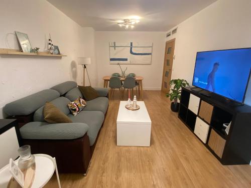 ein Wohnzimmer mit einem Sofa und einem Flachbild-TV in der Unterkunft Apartamento en Málaga Capital - Barrio de Teatinos in Málaga