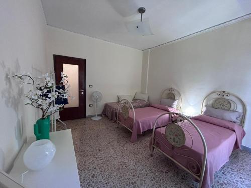 een slaapkamer met 2 bedden, een wastafel en een spiegel bij Laura Domus in Portici