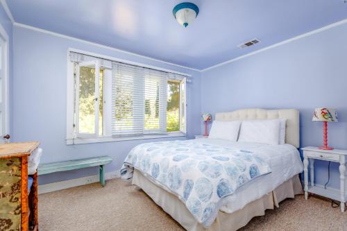 um quarto azul com uma cama e uma janela em The Cottage Guest House em Paso Robles