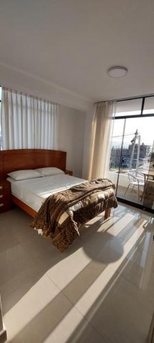 1 dormitorio con cama y ventana grande en R. A. C. S. en Paracas