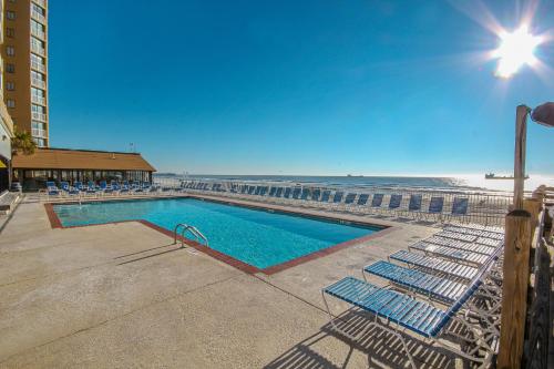 a swimming pool with lounge chairs and the beach at Sands Ocean Club 1630 in Myrtle Beach