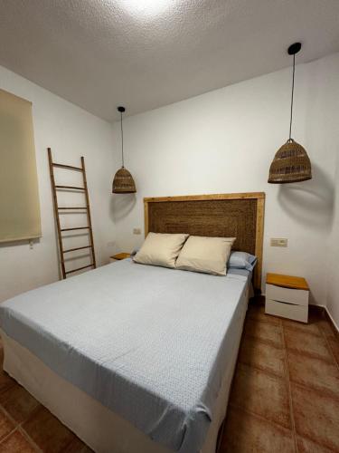 1 dormitorio con 1 cama grande y 2 luces colgantes en Casita Mar de Pulpí, en San Juan de los Terreros