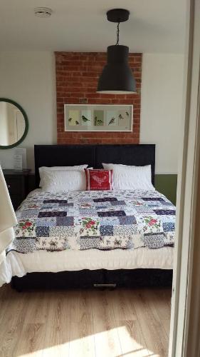 a bedroom with a bed with a quilt on it at The Railway Inn Westerfield in Ipswich