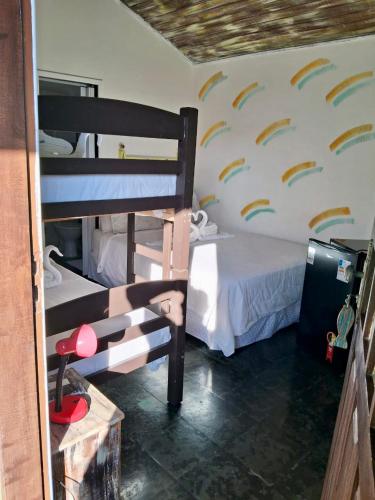 a bedroom with two bunk beds and a wall withbows at Pousada Mare Blue in Búzios