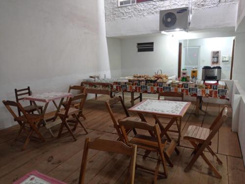um grupo de mesas e cadeiras numa sala em Pousada Videiras Santa Rita de Cássia em Cachoeira Paulista