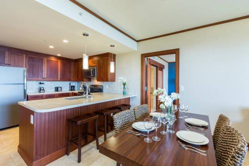 a kitchen with a wooden table with chairs and a sink at Koloa Landing Resort at Po'ipu, Autograph Collection in Koloa