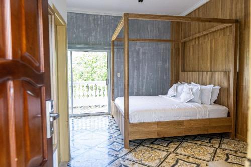 a bedroom with a four poster bed and a door at Hotel Abitti in Taganga