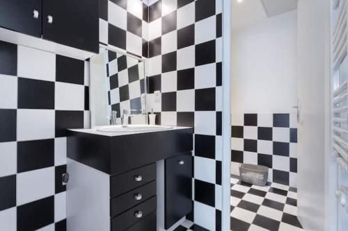 a bathroom with a black and white checkered wall at Calm in the city center of Lyon in Lyon
