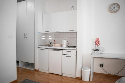 a white kitchen with white cabinets and a sink at Marilyn Monroe 2 Apartman in Mostar