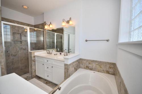 橡树岛Tar Heel Haven的带浴缸、水槽和镜子的浴室