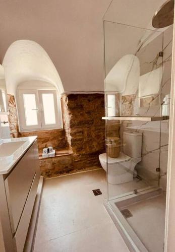 a bathroom with a toilet and a glass wall at Seaside Luxury Komi Beach Villa in Kómi