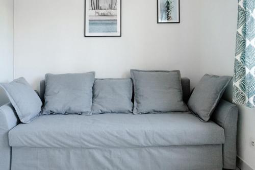 a couch with four pillows in a living room at Le petit Gilibert - studio cosy 2 pers - Perrache in Lyon