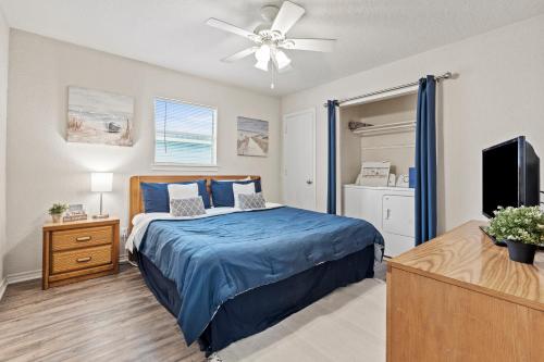 um quarto com uma cama azul e uma televisão em Oceanfront 4BR, Peaceful, Cozy, Kids/Pet Friendly! em Freeport