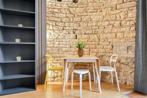 a table and chairs in front of a brick wall at Le petit Sully charmant 4 Pers Foch in Lyon