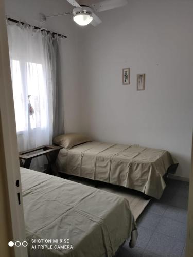 Duas camas num quarto com uma janela em Departamento Duplex em San Juan
