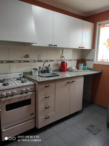 uma cozinha com armários brancos e um forno com placa de fogão em Departamento Duplex em San Juan
