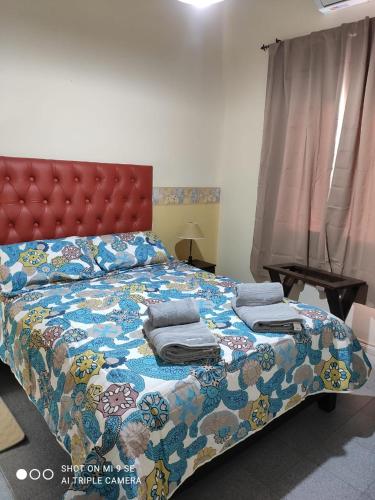 um quarto com uma cama grande e um edredão colorido em Departamento Duplex em San Juan