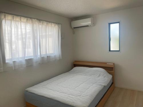 a small bedroom with a bed and a window at ゆうゆう八街新築4LDK free wifi in Yachimata