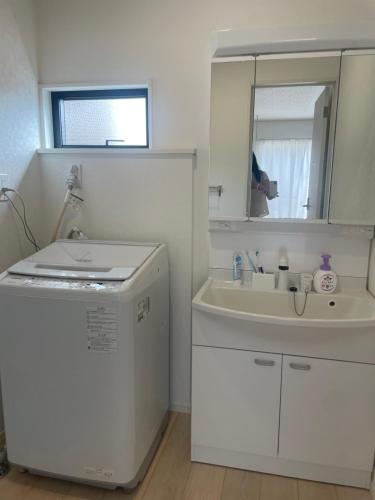 a white bathroom with a sink and a mirror at 広々とした新築戸建 八街駅から徒歩10分車3台駐車可4LDK Free wifi in Yachimata