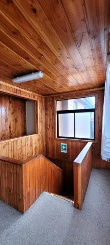 a wooden room with a bench and a window at Hospedajes Roma in Valdivia