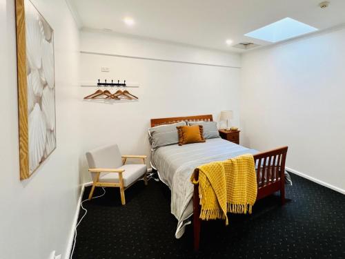 a bedroom with a bed and a chair in it at Talbingo Lodge - Selwyn Accommodation in Talbingo