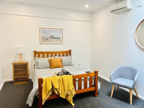 a bedroom with a bed with a teddy bear on a table at Talbingo Lodge - Selwyn Accommodation in Talbingo