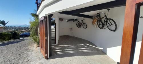 a house with two bikes hanging on the wall at 3Suítes, piscina e vista do mar em condomínio pé na areia - pátio compartilhado in Búzios