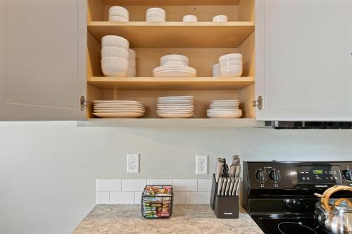 a kitchen with white cabinets and plates on shelves at Mineral Soak Rockers Fire Pit Game Room Fun in Meridian