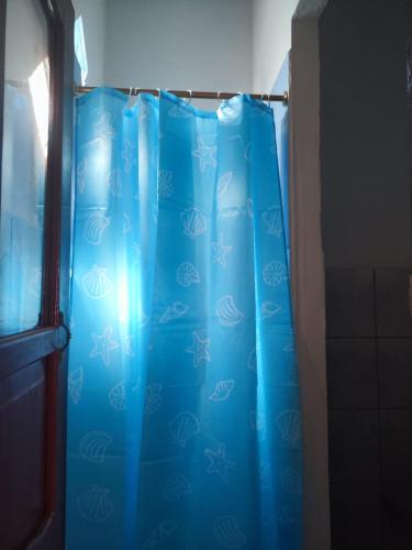 cortina de ducha azul en un baño junto a una puerta en Departamento Shaka en La Libertad