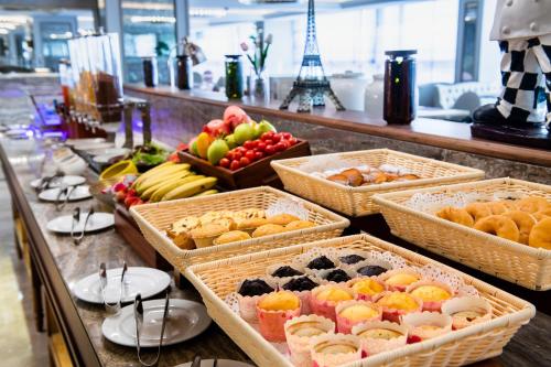 a buffet with baskets of different types of fruit at Mercure Guangzhou Baiyun International Airport - Airport Free Shuttle Bus in Huadu