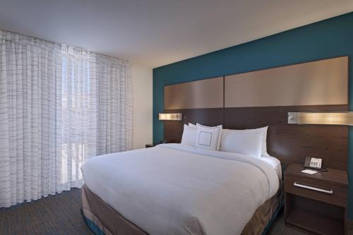 a hotel room with a large bed and a window at Residence Inn by Marriott Jackson The District at Eastover in Jackson