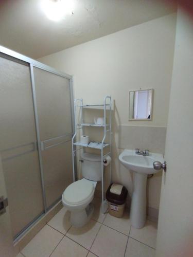 a bathroom with a toilet and a shower and a sink at Apartamento Ely in Lima