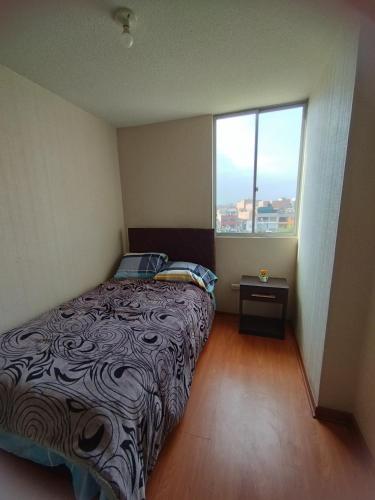a bedroom with a bed and a large window at Apartamento Ely in Lima