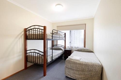 a room with two bunk beds and a window at Allestree Holiday Units in Portland