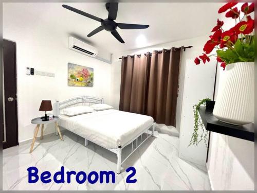 a bedroom with a bed and a ceiling fan at Modern HS Sweet Homestay Kuantan in Kuantan