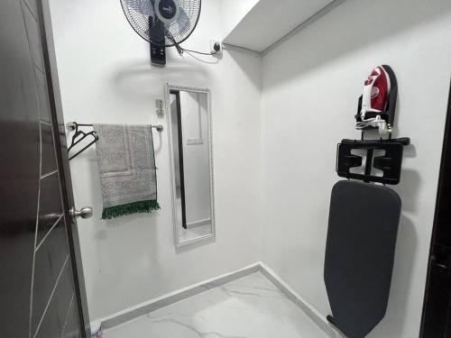 a white bathroom with a fan and a mirror at Modern HS Sweet Homestay Kuantan in Kuantan