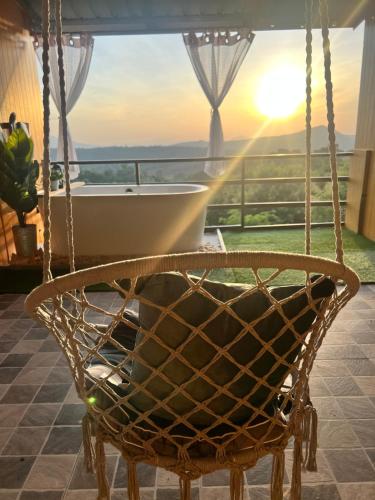 a swing in front of a balcony with a tub at บ้านภูไผ่ ไร่ภูไผ่เบิกตะวัน in Ban Nam Phang