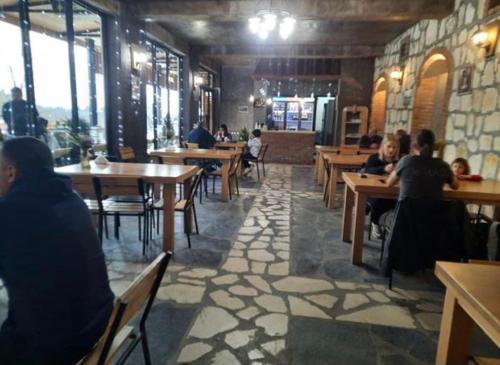 a restaurant with wooden tables and people sitting at tables at Hotel Canionel in Martvili