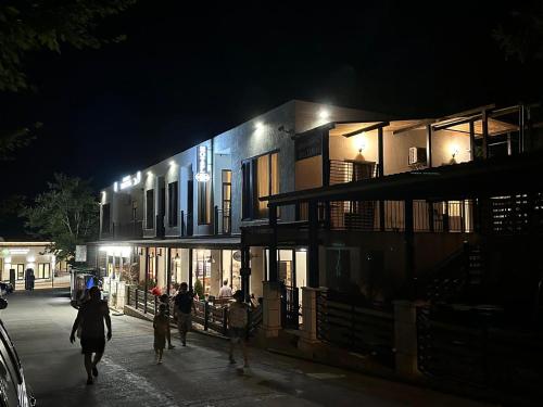 un grupo de personas caminando por una calle por la noche en Hotel Canionel en Martvili