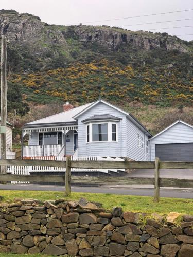 a house with a fence in front of a mountain at Number 10 -Queen Room with b/fast in Stanley